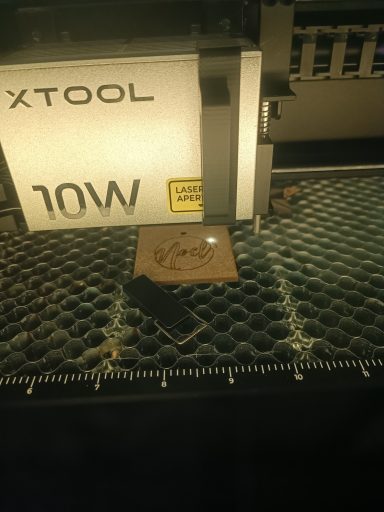 Gravure et découpe laser Machine Xtool 10W avec un objet découpé sur une surface de travail.